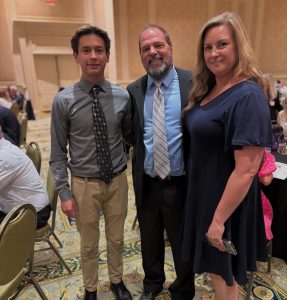 From left to right: Senior Chris Castillo, Christopher Barnhart and Christina Barnhart smile after both Barnharts were awarded Coach of the Year at Virginia Beach Sports Club Jamboree on June 5, 2025. Photo used with permission by Christina Barnhart.